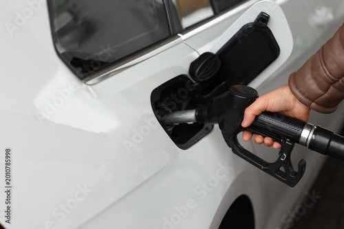 Slika na platnu Male hand refueling car at modern gasoline station, closeup