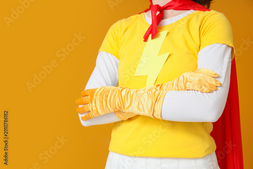 Foto Young woman in superhero costume on orange background, closeup