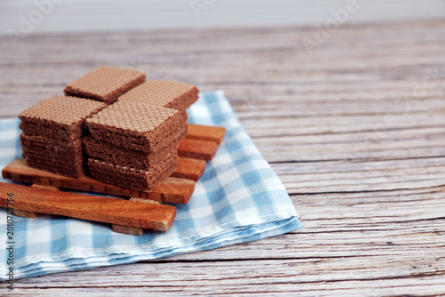 Canvas-taulu Chocolate wafers stacked neatly on wooden serving board