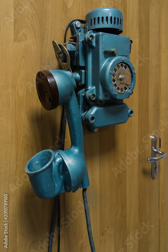 фотографія Old industrial disk telephone on wooden wall