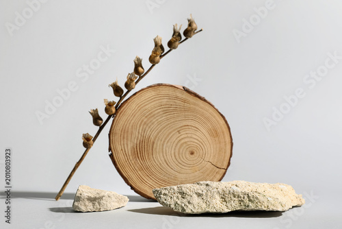Tableau sur toile Wooden board with henbane seed pods and stones on grey background