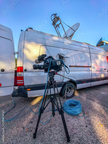 Professional television camera and satellite mobile unit for live news broadcasting.