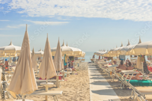 Canvas Print Sunny beach scene with umbrellas and lounge chairs at a coastal resort during mi