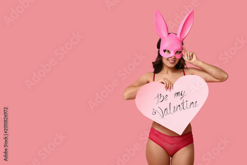 Beautiful young Asian woman in bunny mask and sexy lingerie with paper heart ...