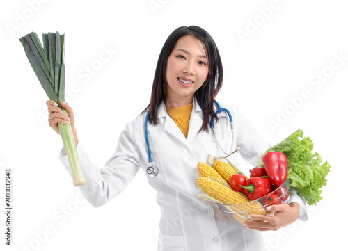 Female Asian nutritionist with vegetables on white background