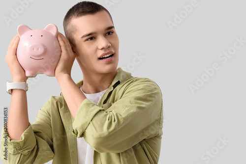 Young man with piggy bank o...