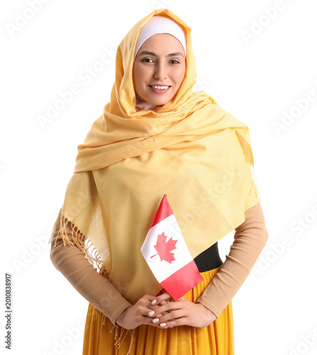 Young Muslim woman with flag of Canada on white background