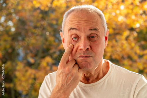 Tableau sur toile mature male face man 50-55 years old, looks examines wrinkles around eyes, skin