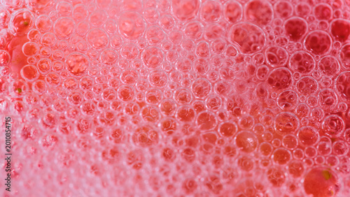 Quadro su tela Close up view of bubbles in a fizzy drink served in a clear glass on a sunny day