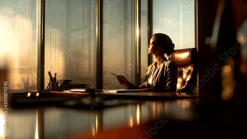 Businesswoman in Office Overlooking Sunset View
