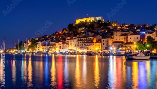 A serene nighttime view of a coastal town's harbor