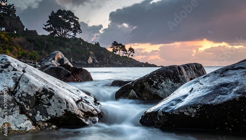 A serene seascape with rocks and flowing water at sunset