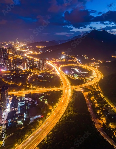 Aerial view of a city at night with a highway and buildings