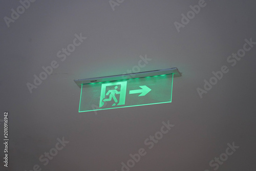 Принти на полотні Green fire escape sign hang on the ceiling in the office.