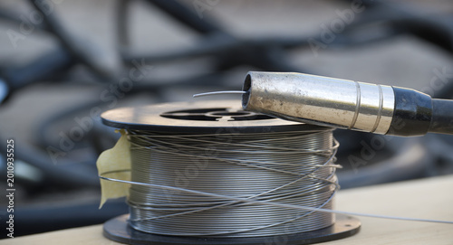 Welding wire spool and MIG gun nozzle ready for metal fabrication work