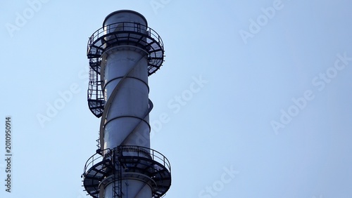 Industrial Chimney Stack With Spiral Staircase Against Clear Sky