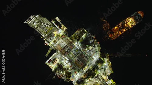 Aerial top view of offshore jack up rig and offshore platform during sunset for oil and gas exploration and production. 