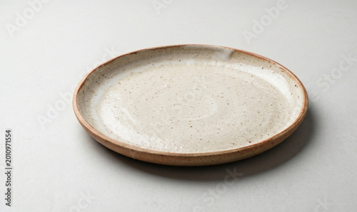 Minimalist ceramic plate side view, empty stoneware dinnerware photography, rustic handmade pottery dish, neutral kitchen tableware mockup, craft ceramic serving platter, high resolution product photo