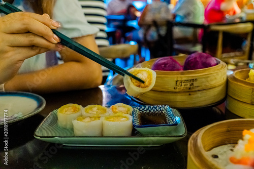 Fotografía Customer lifting steamed shrimp dumpling with chopsticks at Asian dim sum restau