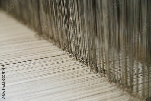 Cuadro en lienzo Macro view of warp threads and heddle threads on a weaving loom