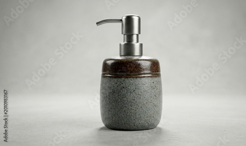 Ceramic soap dispenser bottle, grey stone texture, modern bathroom accessory, liquid soap pump, minimalist hygiene product, interior design decor, clean washroom element
