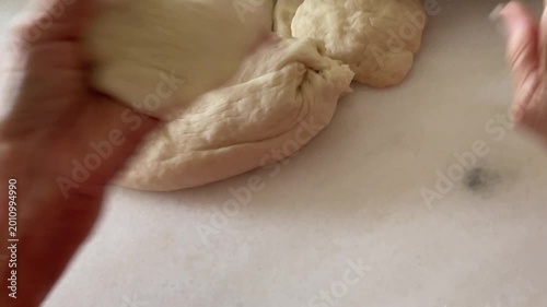 A close-up captures the authentic process of hands flattening a circular dough wrapper before using a spoon to add a generous portion of minced meat and petai stuffing for handmade baozi.