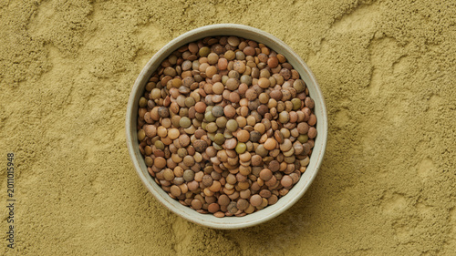 Braune Linsen in Keramikschale auf Kalkputz, Makro