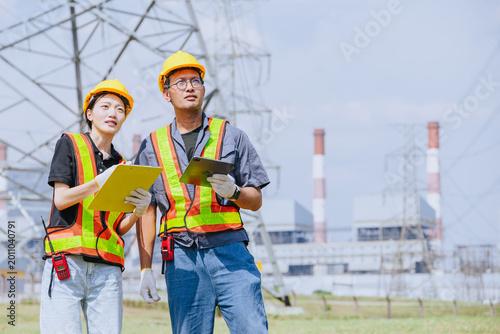 Electricity engineer working team against power plant background and power line survey inspector