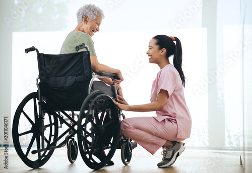 Tableau sur toile Nurse, old woman and laugh in wheelchair at window in morning, healing and funny story in retirement home