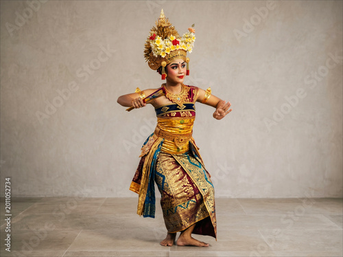 Graceful Balinese Traditional Dancer in Full Golden Attire. A graceful Balinese dancer poses elegantly in a stunning traditional golden costume and crown