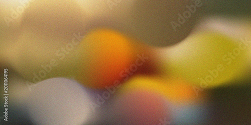 Abstract background featuring soft, out-of-focus colorful light spots with a grainy texture, creating a dreamy and artistic atmosphere.