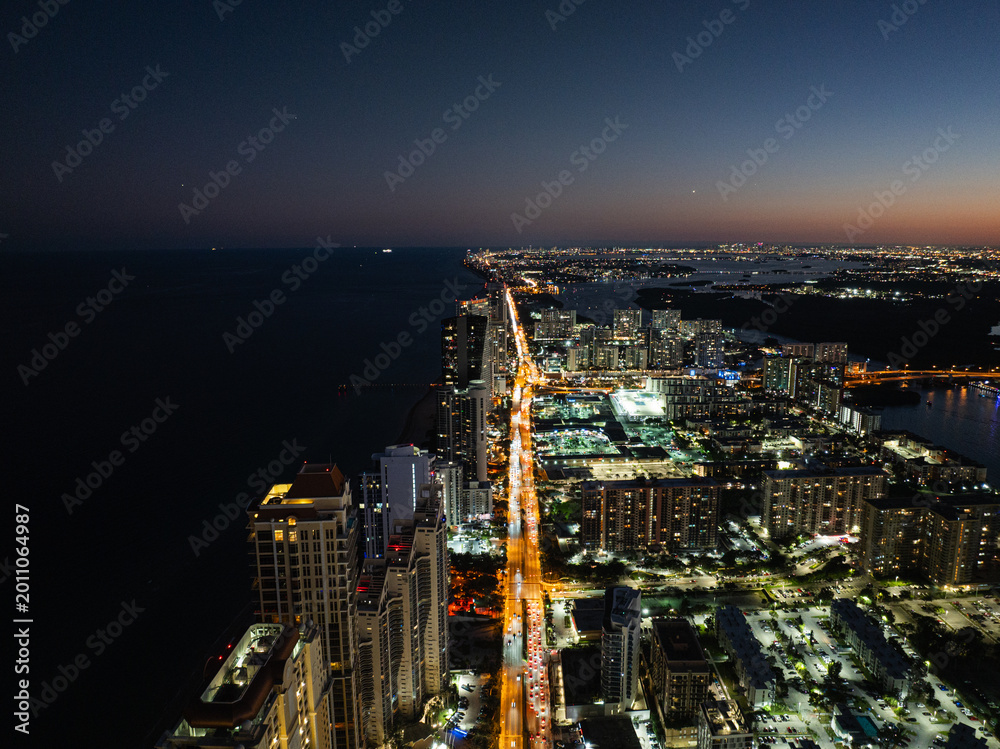 Obraz premium Aerial night view of Miami skyline and Biscayne Bay with city lights, Florida USA