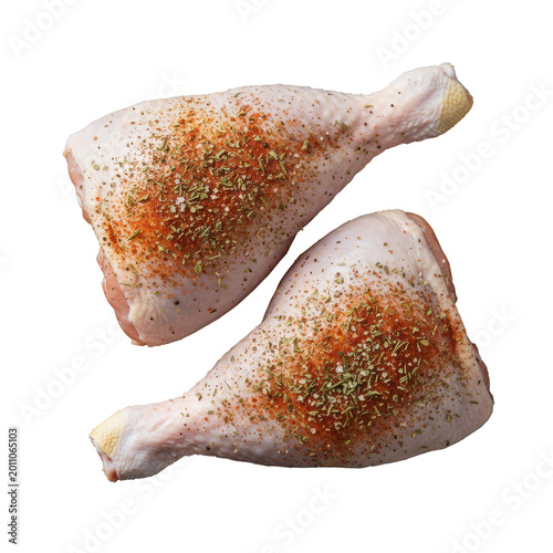 Two large raw chicken leg quarters coated in vibrant paprika and herb dry rub, set on a dark rustic wood cutting board in a sharp, minimalist flat lay, commercial food preparation atmosphere