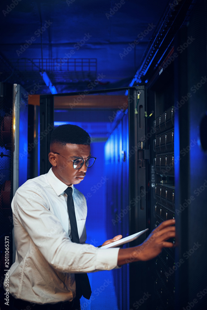 Fototapeta premium Technician, man or tablet with server room inspection for rack maintenance, system backup or solution. IT engineer, black person or tech in dark data center for diagnostics, hardware check or upgrade