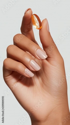 Hand holding capsule in close view capturing healthcare wellness and modern lifestyle with soft lighting and minimal clean composition