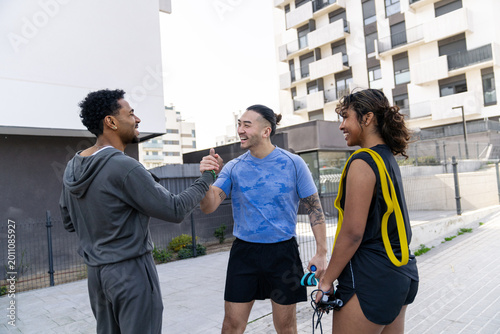Slika na platnu Happy young fit people celebrating teamwork with a high five after training outd