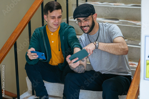 Two men discussing content on smartphone