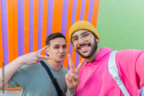 Two Latino men taking selfie with peace signs