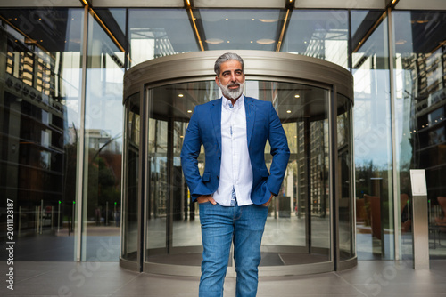 Confident businessman standing outside modern office building