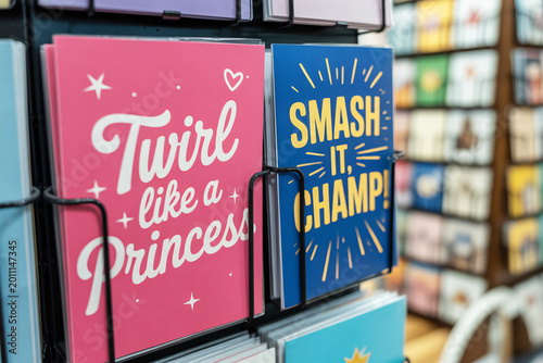 Pink and blue birtday greeting cards on a rack. Gender stereotypes and societal expectations taught from a young age through color-coded messages.