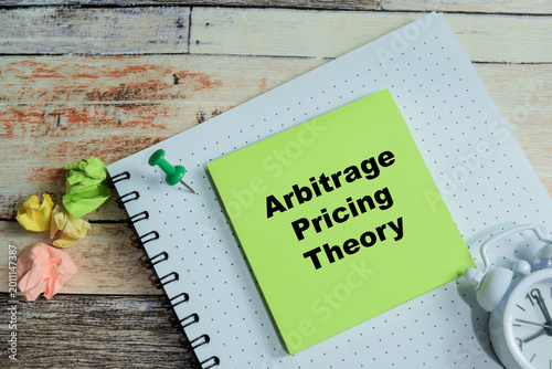 Fotografie Concept of arbitrage pricing theory write on sticky notes isolated on Wooden Table