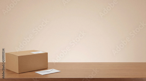 Cuadro en lienzo A simple brown cardboard package box and a white envelope resting on a wooden table, offering generous copy space