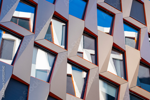 Angles and colorful windows shape an abstract pattern on a modern facade as geometry and architecture merge into graphic design details