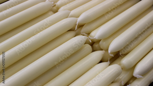 Bild auf Leinwand New natural colored paraffin candles are stacked before packaging after producti