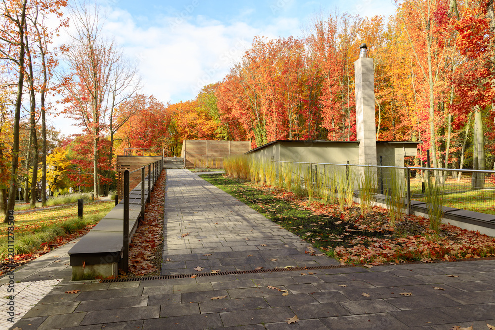 Naklejka premium Modern building nestled in a vibrant autumn forest with colorful foliage