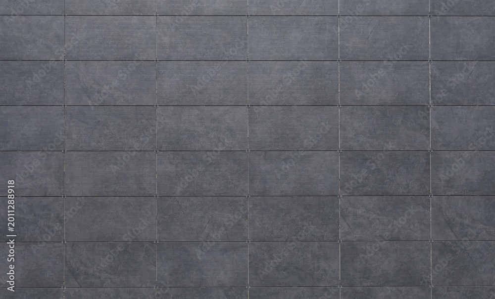 Fototapeta premium Dark gray sintered stone tiles coating of a ventilated facade. Background and texture.
