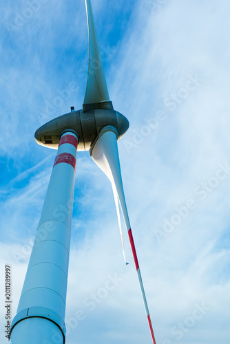 Foto wind turbines of wind power plant producing electricity on green sunset hills and cloudy sky on background of landscape