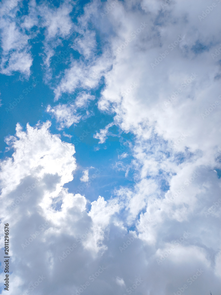 Obraz premium Dramatic Vertical View of Sun Hiding Behind Clouds with Silver Lining Effect