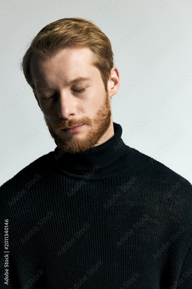 Obraz premium Stylish young man exuding confidence in a trendy black turtleneck sweater