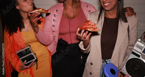 Group of multiracial girls having fun eating pizza together while listening music with vintage retro devices outdoor - Party, nightlife and people lifestyle concept 
